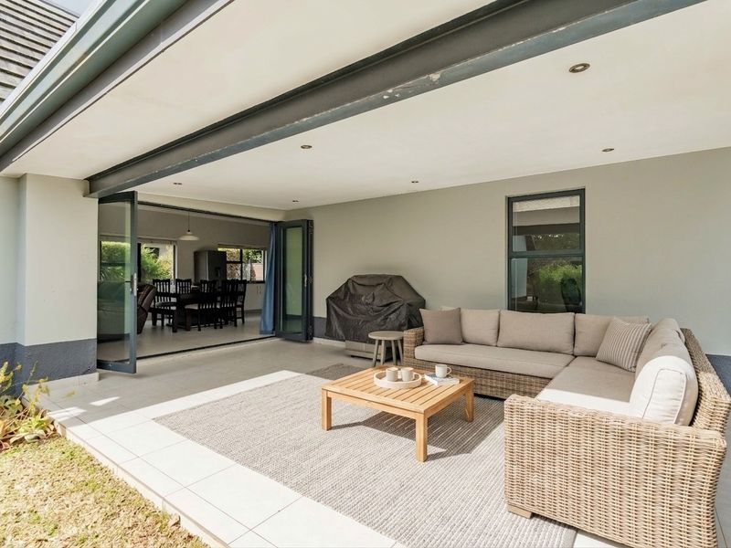 A spacious covered patio featuring tiled flooring and bi-fold doors that provide seamless indoor-outdoor flow to the main living area.
