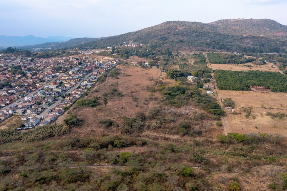 An aerial view showing the surrounding landscape, nearby residential development, and natural terrain features.