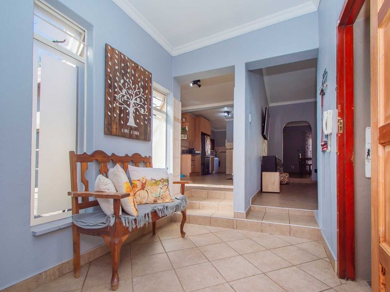 Entrance foyer featuring tiled flooring and a stepped transition leading into the open-plan living and kitchen areas.