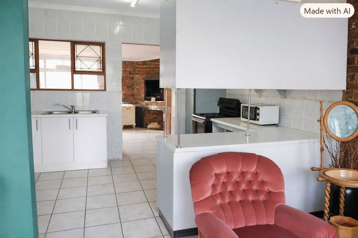 A functional kitchen featuring tiled flooring, built-in cabinetry, and a breakfast bar, with an adjacent living area visible through the doorway.