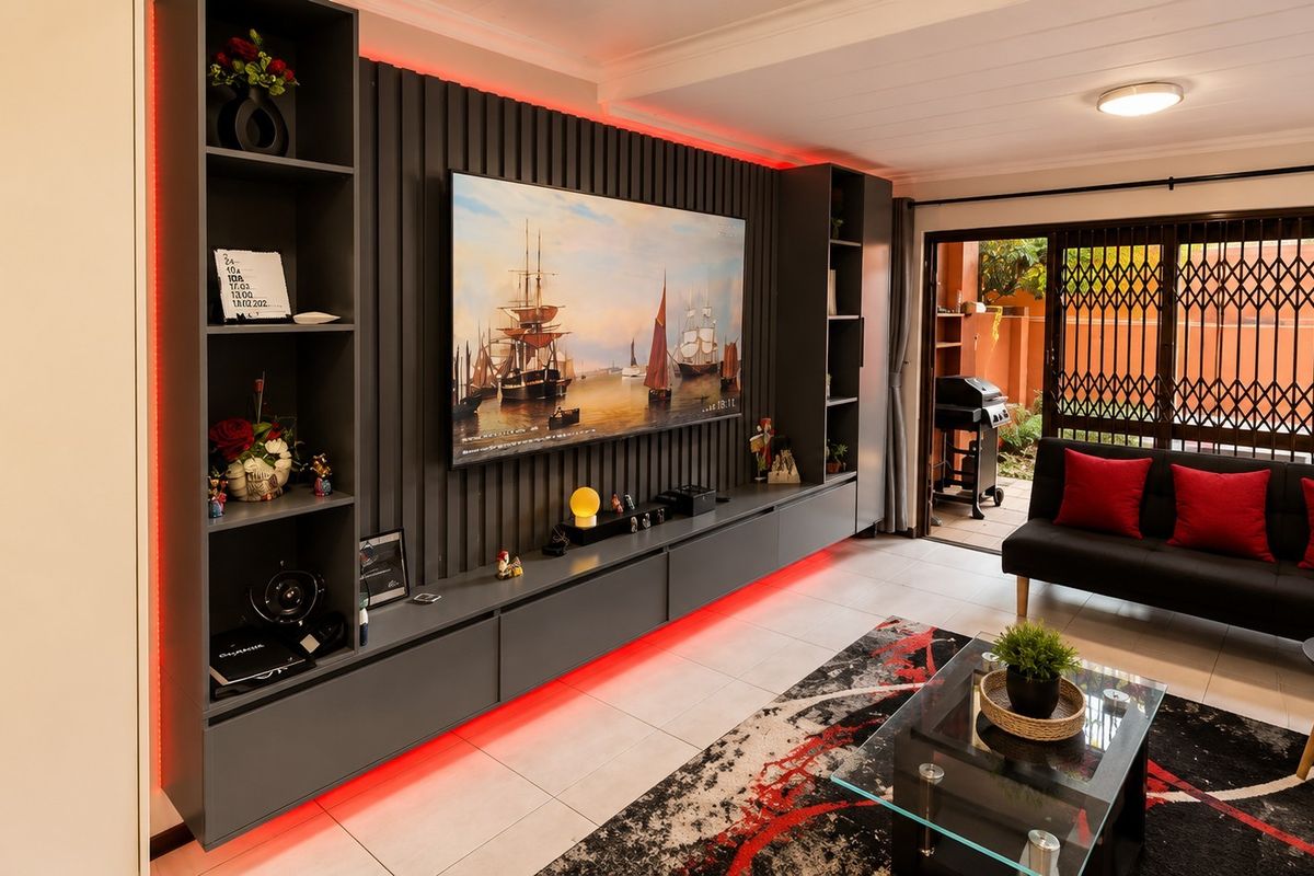 Modern living room featuring custom built-in cabinetry with integrated LED lighting, tiled floors, and direct access to an outdoor patio area.