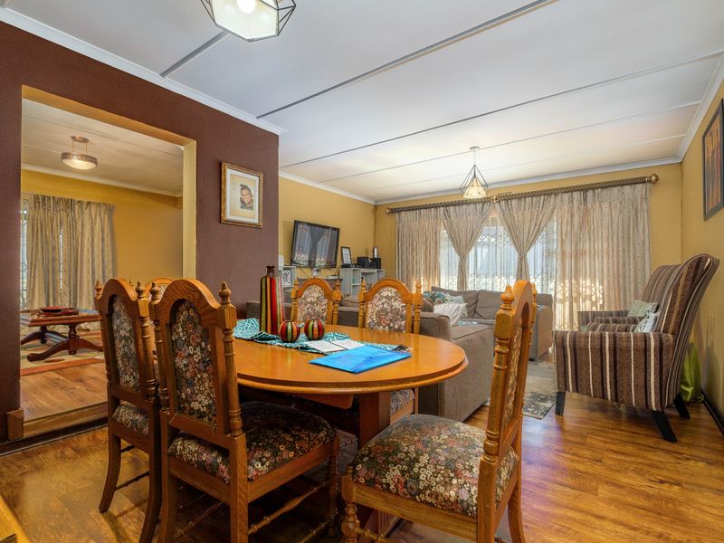 Open plan living and dining area featuring laminate flooring and neutral wall tones, providing a functional and connected space for family living.