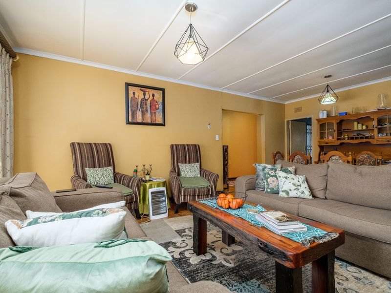 A comfortable living room featuring a classic exposed beam ceiling and warm wall tones, providing a functional and inviting space for relaxation.