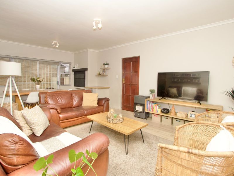 Spacious open-plan living area featuring laminate flooring, a built-in fireplace, and neutral wall finishes, creating a comfortable and functional family space.