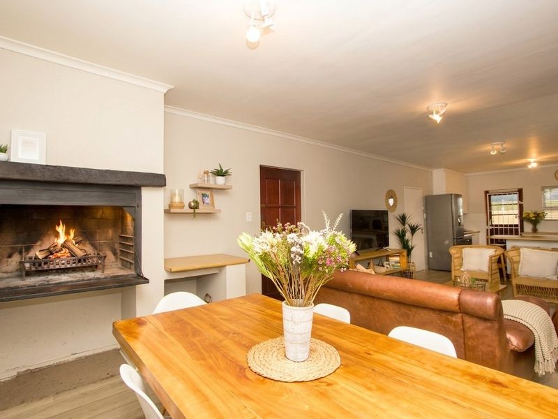 Spacious open-plan living and dining area featuring a built-in fireplace, neutral finishes, and a seamless flow into the kitchen space.