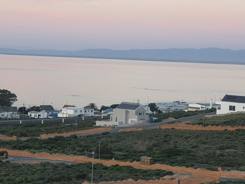 A scenic elevated view overlooking the coastal landscape and ocean, capturing the surrounding neighbourhood and natural environment.