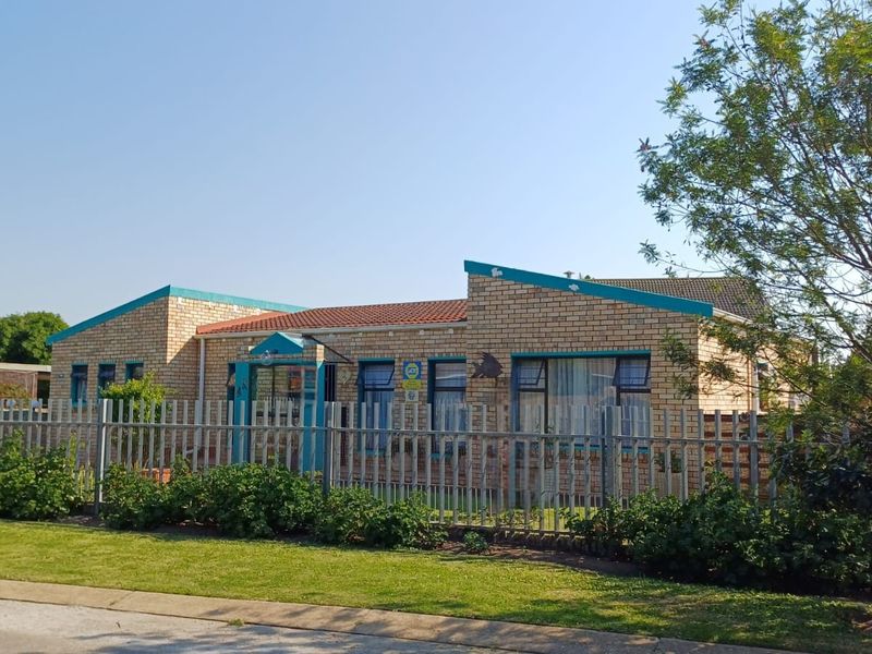A single-story face brick house featuring a tiled roof, secure metal palisade fencing, and a well-maintained front garden area.