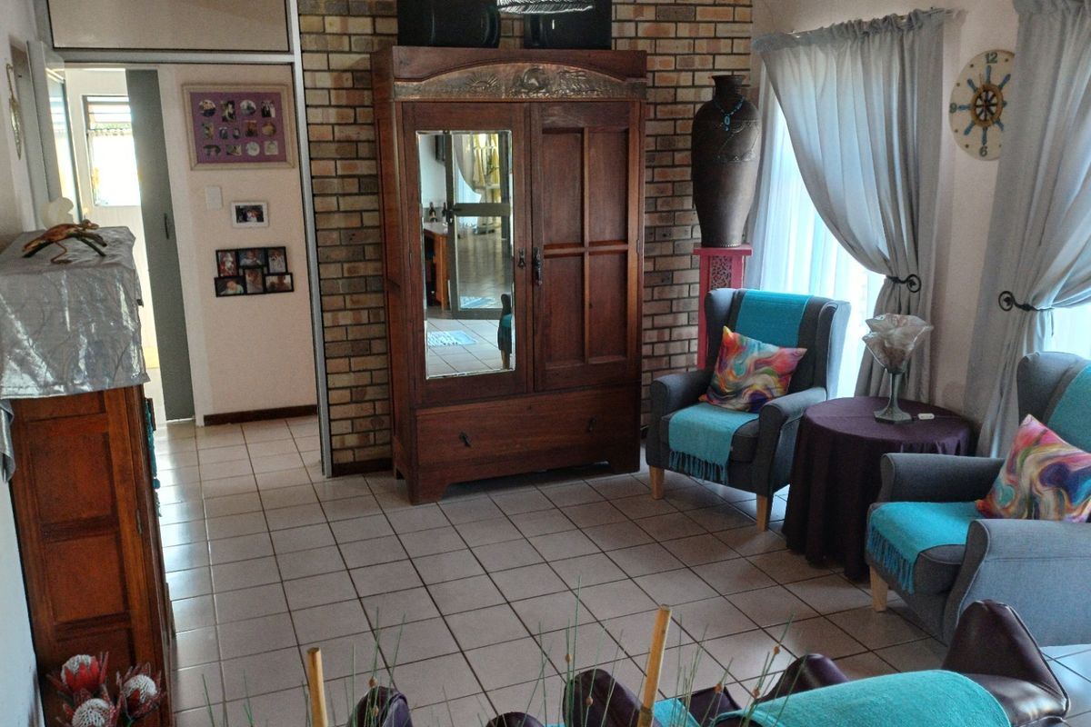 A living room featuring a prominent exposed brick wall and neutral ceramic floor tiles, offering a solid foundation for updated interior styling.