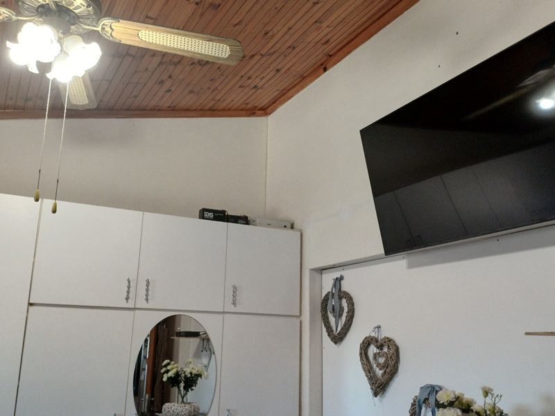 Bedroom featuring a timber-clad raked ceiling, ceiling fan, and extensive built-in cupboard storage.