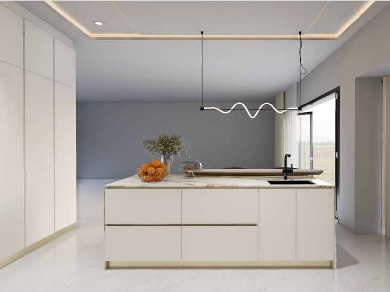 A modern, high-end kitchen featuring a sleek central island with integrated sink, minimalist cabinetry, and sophisticated pendant lighting in a bright, open-plan space.