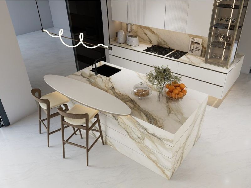 Modern luxury kitchen featuring a striking marble island with integrated sink, sleek handleless cabinetry, and high-end built-in appliances.