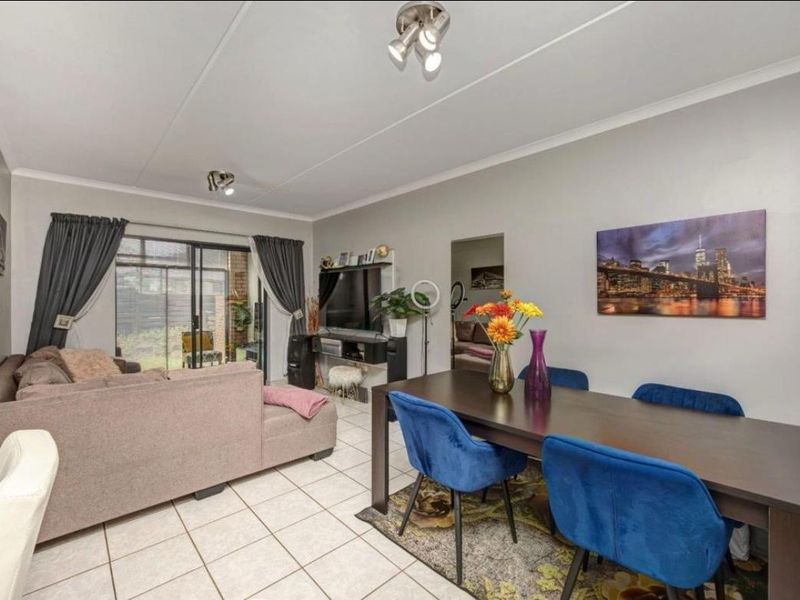 Open plan living and dining area featuring ceramic floor tiles, coved ceilings, and large sliding glass doors providing access to the exterior.