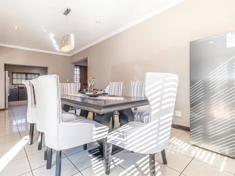 A dining area featuring tiled flooring, coved ceilings, and recessed lighting, providing a functional space for meals with direct access to the kitchen.