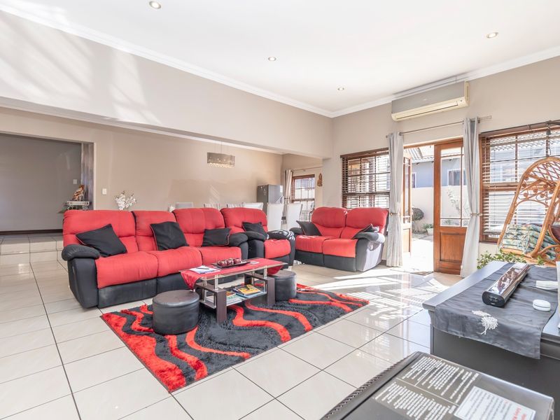 Spacious living room featuring tiled flooring, recessed lighting, and an integrated air conditioning unit, with direct access to the outdoor area.