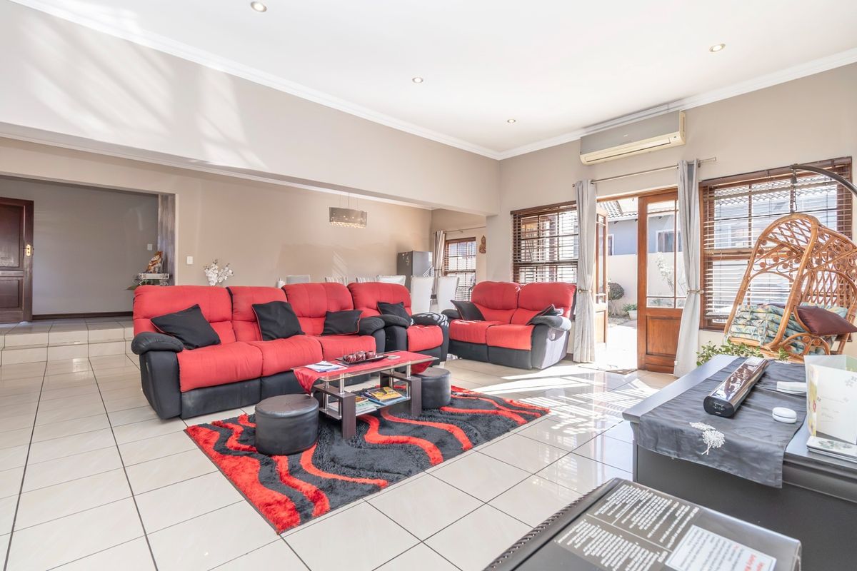 Spacious living room featuring tiled flooring, recessed lighting, and an integrated air conditioning unit, with direct access to the outdoor area.