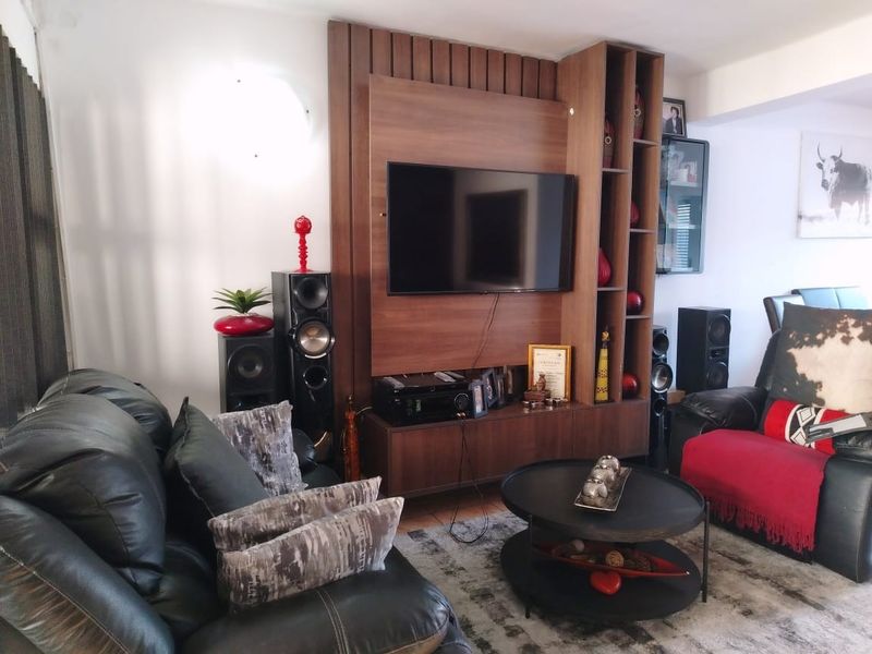 A comfortable living room featuring a custom-built timber media wall unit with integrated shelving and cabinetry.