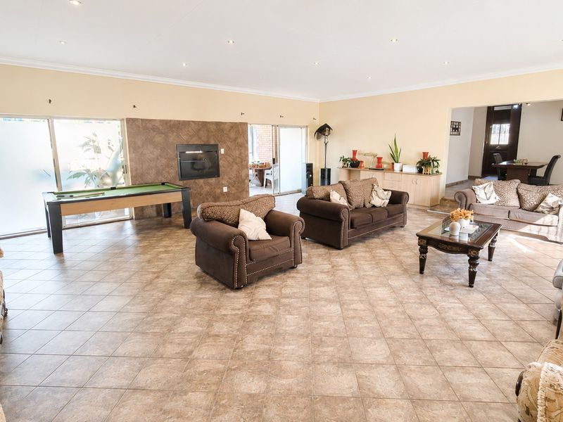 Spacious living room featuring tiled flooring, recessed lighting, and a built-in fireplace with direct access to the outdoor area through sliding glass doors.