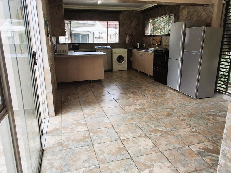 Functional kitchen area featuring tiled flooring, built-in cabinetry, and direct access to the outdoor space through a sliding glass door.