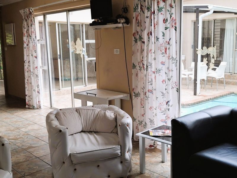 Open plan living area featuring tiled floors and large sliding glass doors providing direct access to the outdoor pool and patio area.