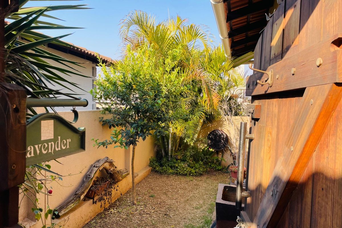 A private side garden area featuring a timber gate, boundary wall, and established greenery, providing a secluded outdoor space.