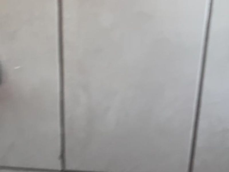 A low-quality screenshot of a tiled surface, likely from a mobile device interface.