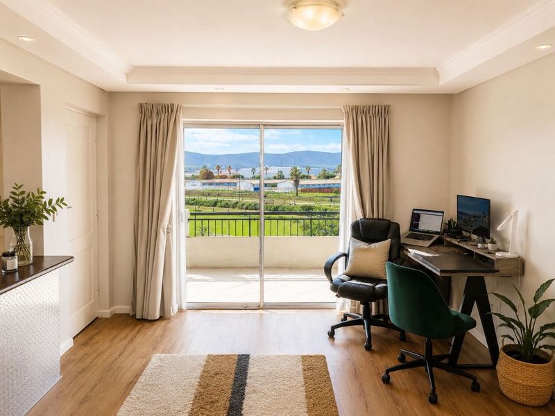 Bright living area featuring laminate flooring, recessed lighting, and large sliding glass doors opening onto a balcony with scenic views.