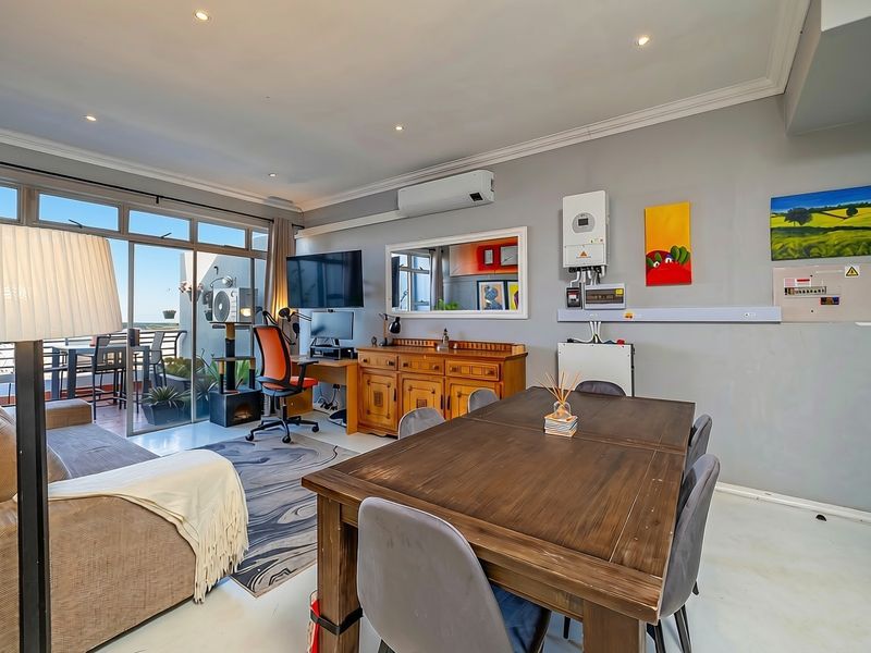 Open-plan living and dining area featuring recessed lighting, air conditioning, and large sliding doors leading to an outdoor balcony space.