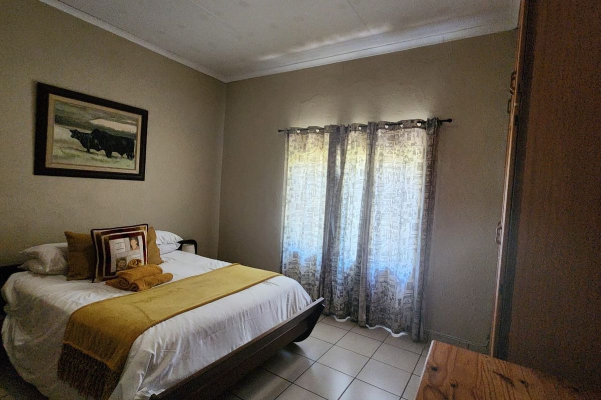 A functional bedroom featuring tiled flooring and a built-in cupboard, offering a neutral base for interior updates.
