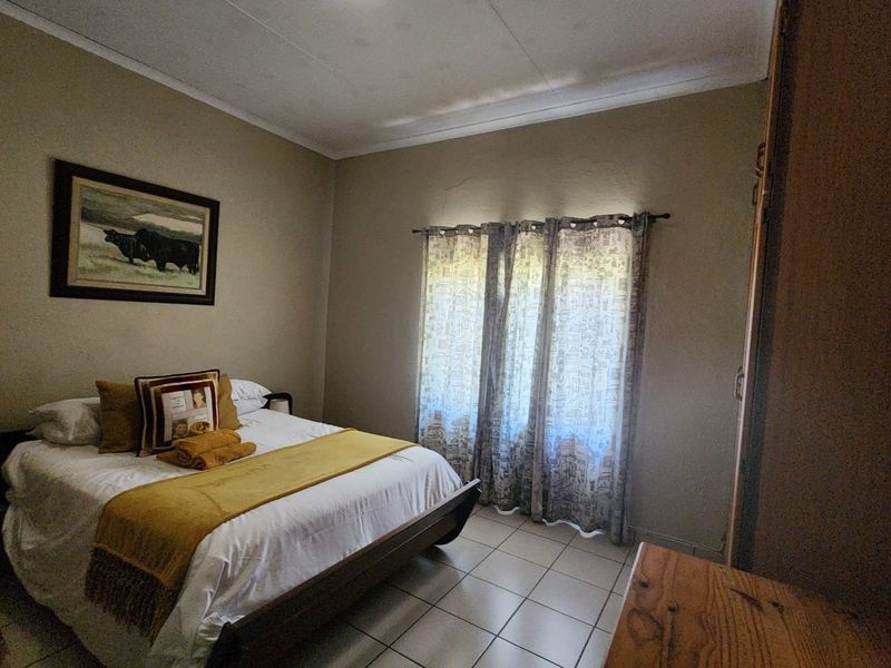 A functional bedroom featuring tiled flooring and a built-in cupboard, offering a neutral base for interior updates.