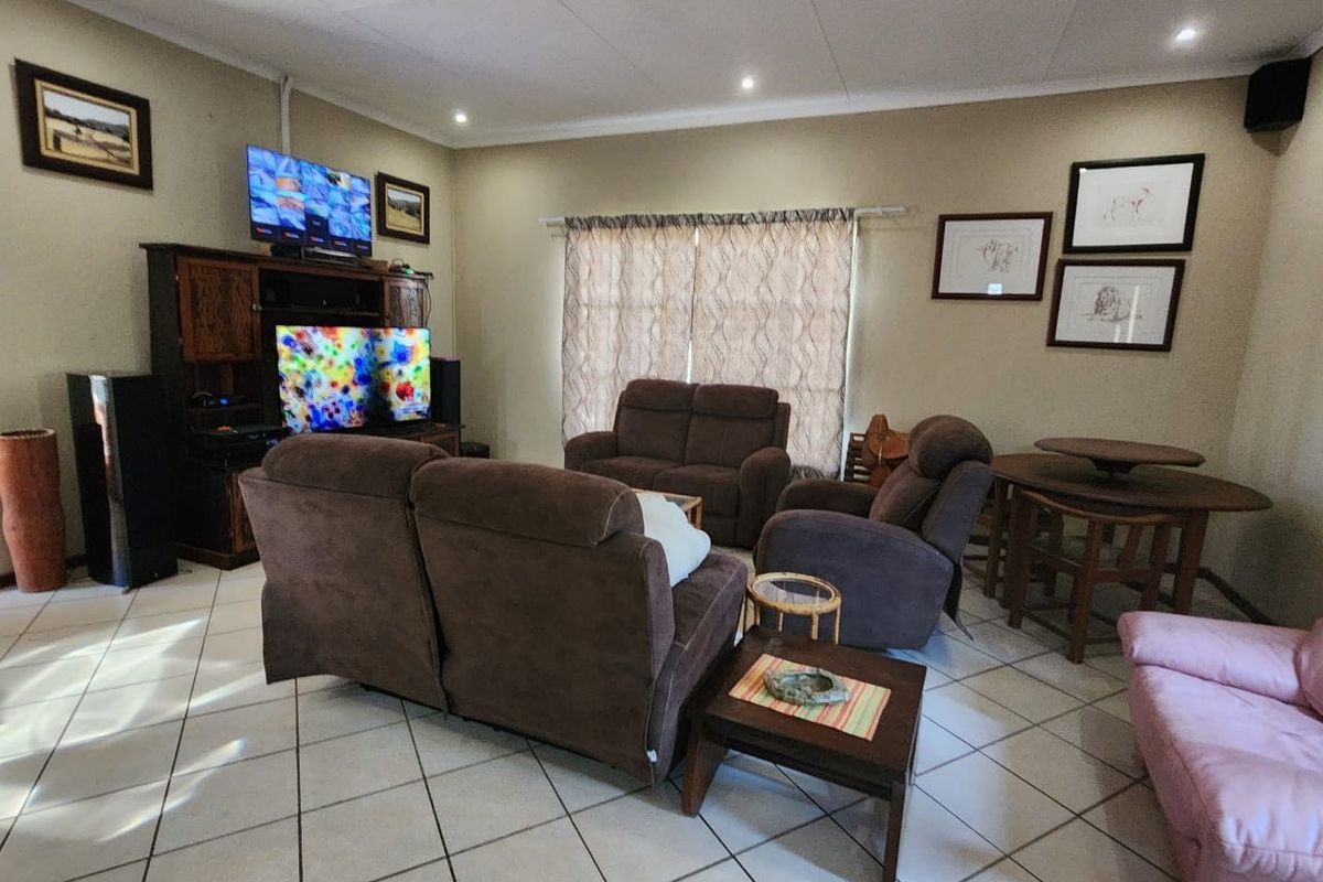 A comfortable living room featuring tiled flooring, recessed ceiling lighting, and coved cornicing, providing a functional and well-lit space for relaxation.