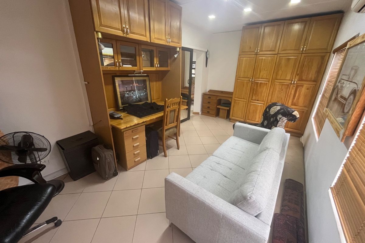 A bedroom featuring extensive built-in wooden cabinetry, a integrated desk workspace, tiled flooring, and recessed ceiling lighting.