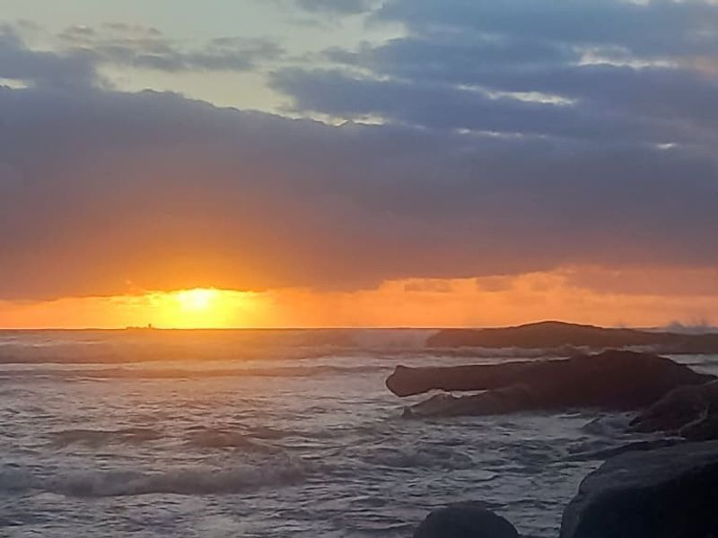 A scenic view of the ocean at sunset, showcasing the natural landscape and coastal horizon.