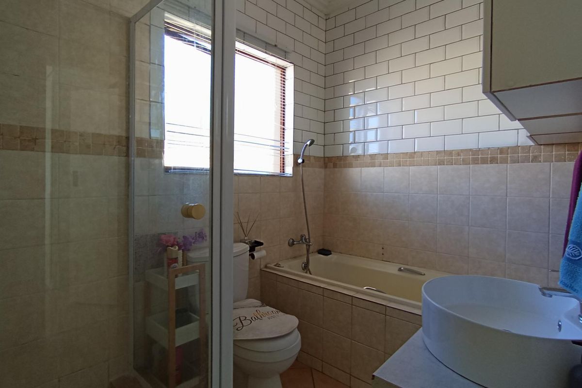 A functional bathroom featuring a shower enclosure, bathtub, toilet, and a modern vessel sink with subway tile wall finishes.