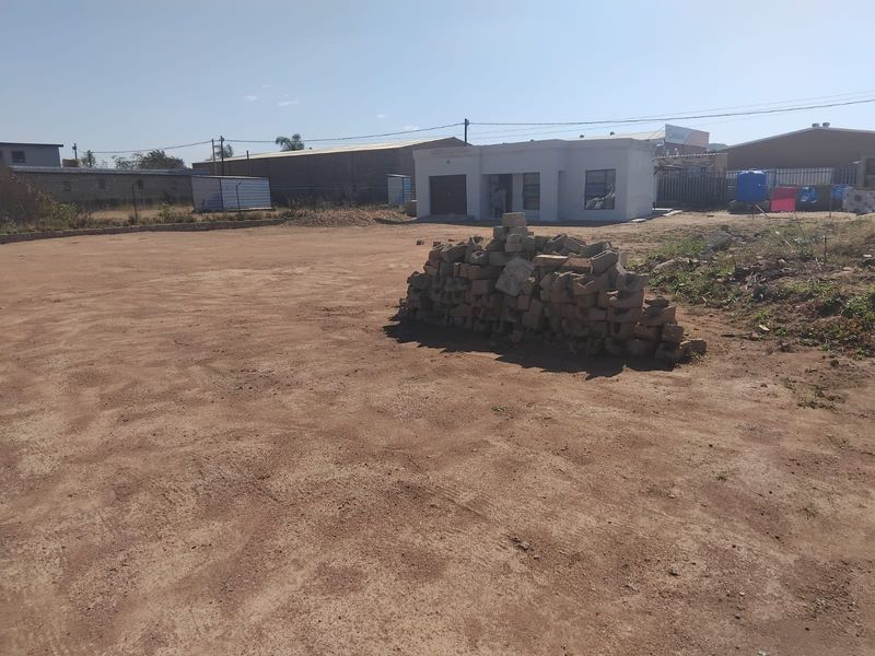 A vacant residential plot featuring an unpaved surface and a small existing structure, offering potential for future development or landscaping.