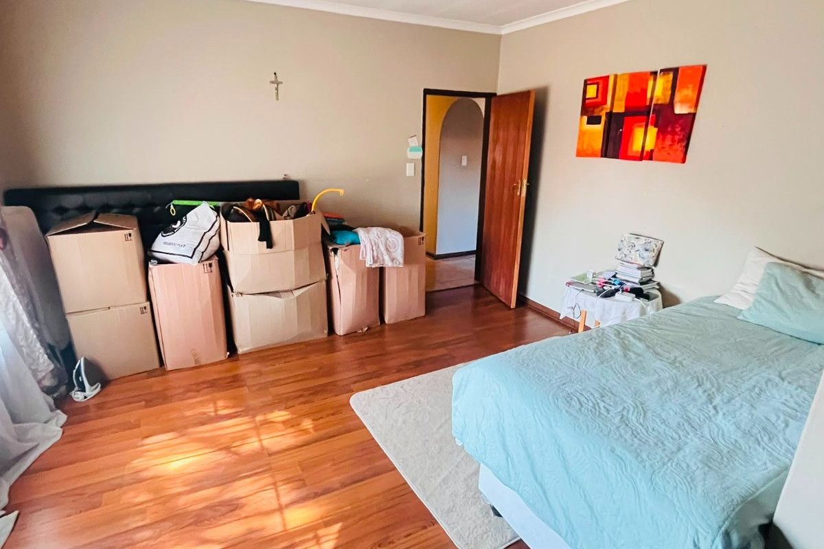 A bedroom featuring laminate flooring and coved ceilings, offering a functional space ready for personalization.