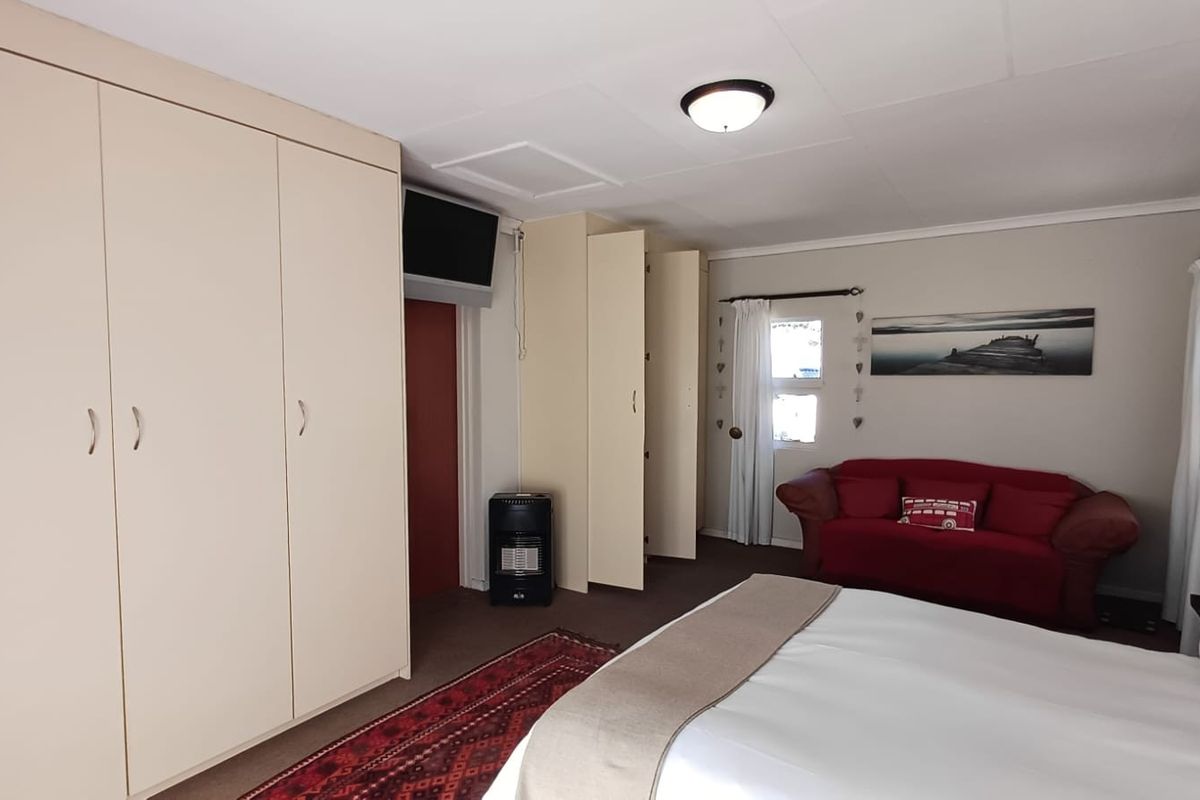 A bedroom featuring built-in cupboards and neutral wall finishes, providing a functional space with natural light.
