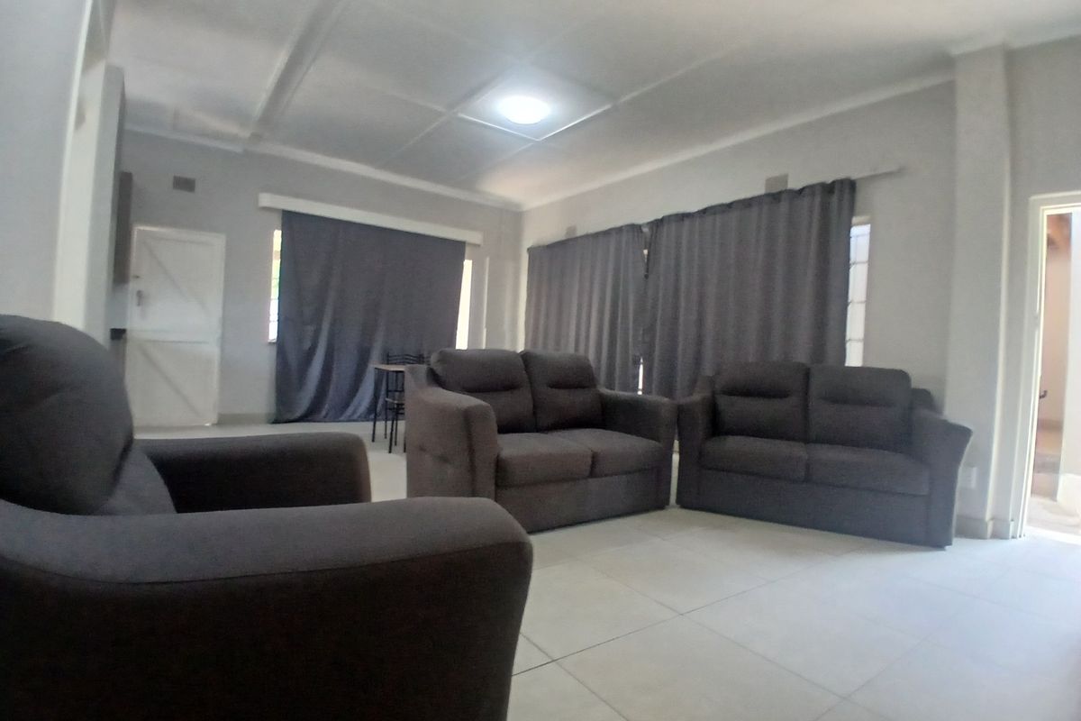 A spacious living room featuring neutral tiled flooring and a recessed ceiling design, providing a clean and functional base for interior styling.