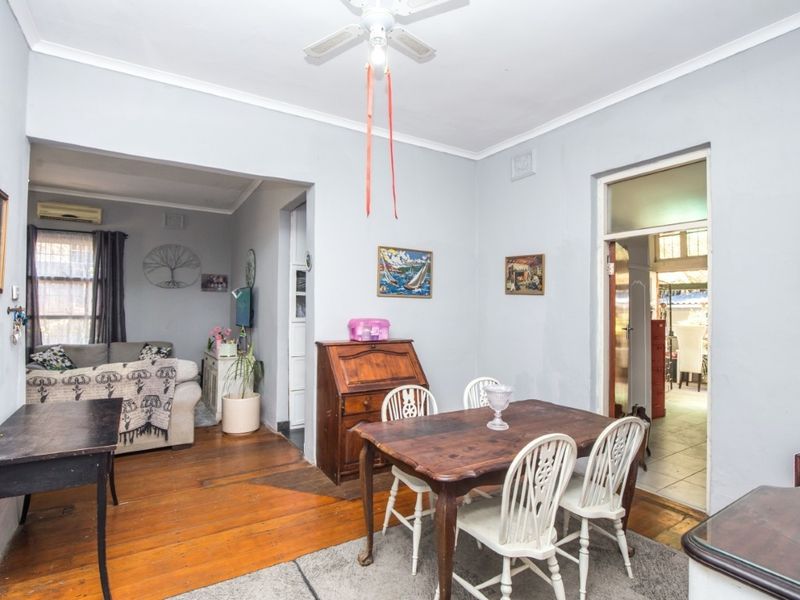 Open plan living and dining area featuring timber flooring, ceiling fan, and neutral wall tones, providing a versatile space for family living.