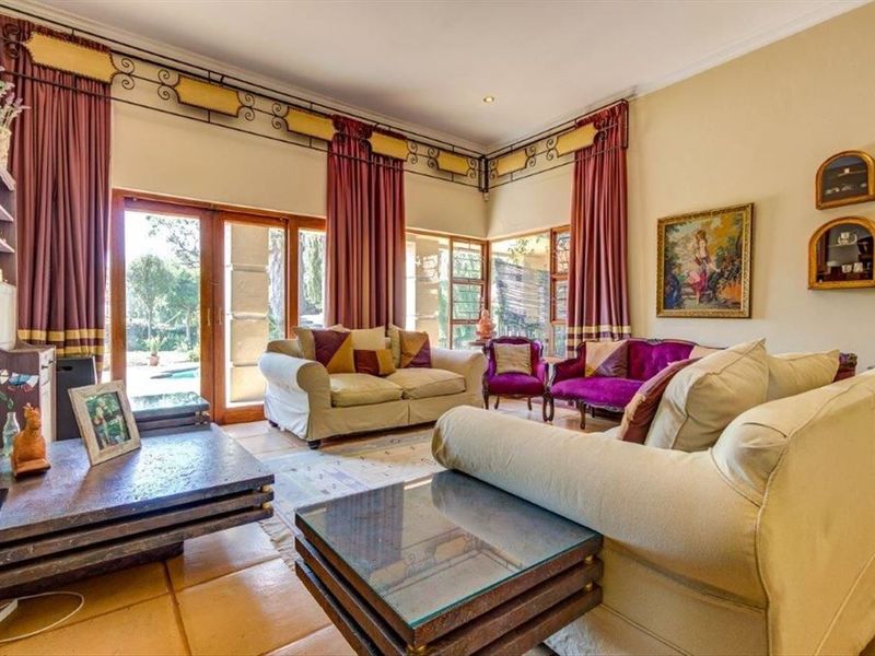 Spacious living room featuring terracotta floor tiles, recessed lighting, and large sliding glass doors providing direct access to the outdoor pool area.