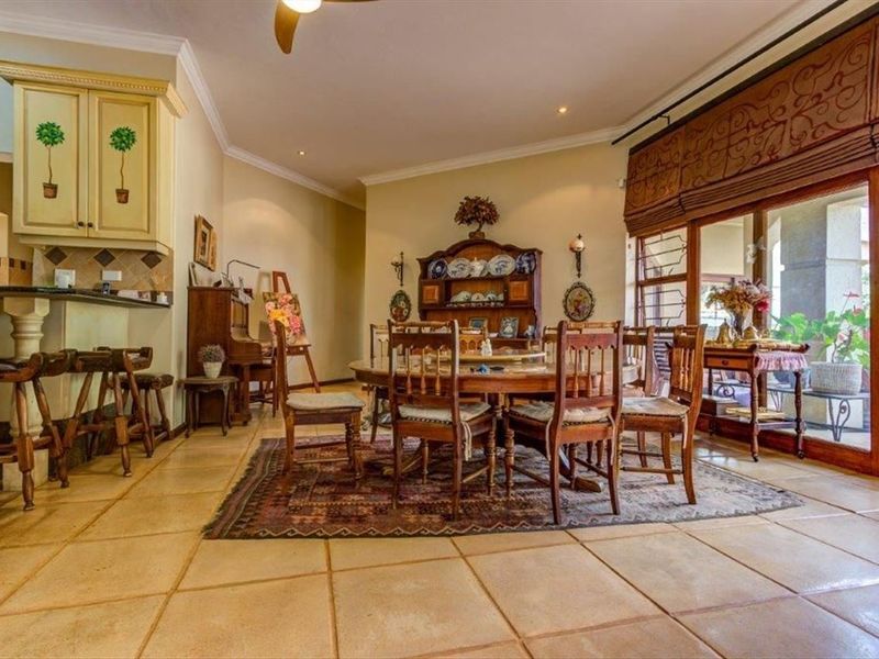 Spacious open-plan dining and kitchen area featuring large floor tiles, recessed lighting, and sliding glass doors providing access to the outdoor patio.