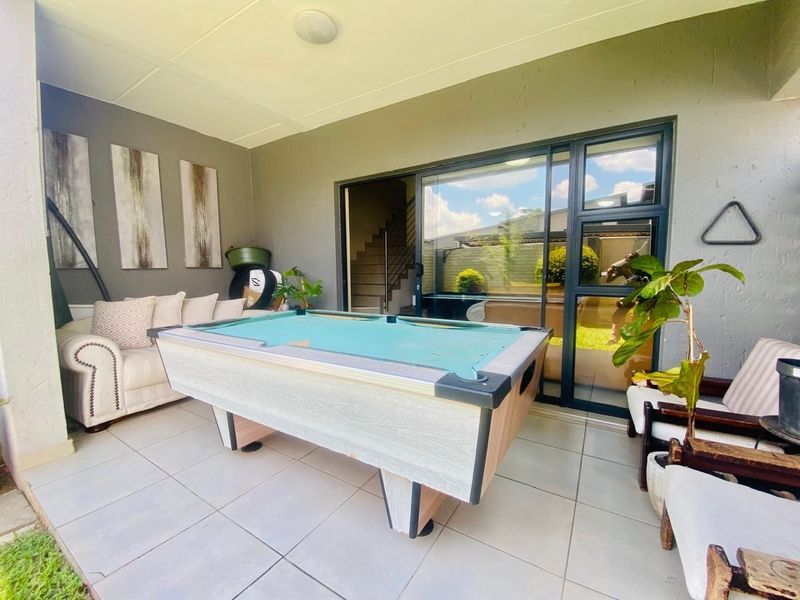 A covered patio area featuring tiled flooring and large sliding glass doors providing access to the interior living space.
