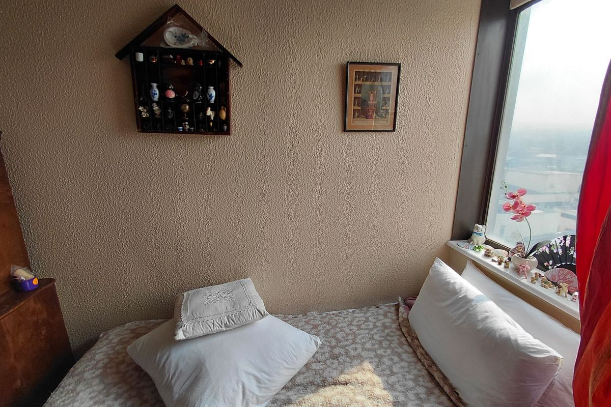 A bedroom featuring a large window with natural light and textured wall finishes, offering a comfortable space within the retirement village.