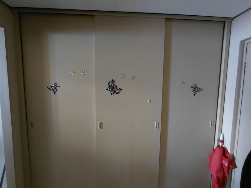 A bedroom featuring a large built-in sliding door wardrobe with neutral finish.