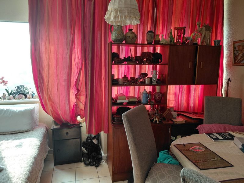 A bedroom featuring tiled flooring and a large window, providing natural light to the space.