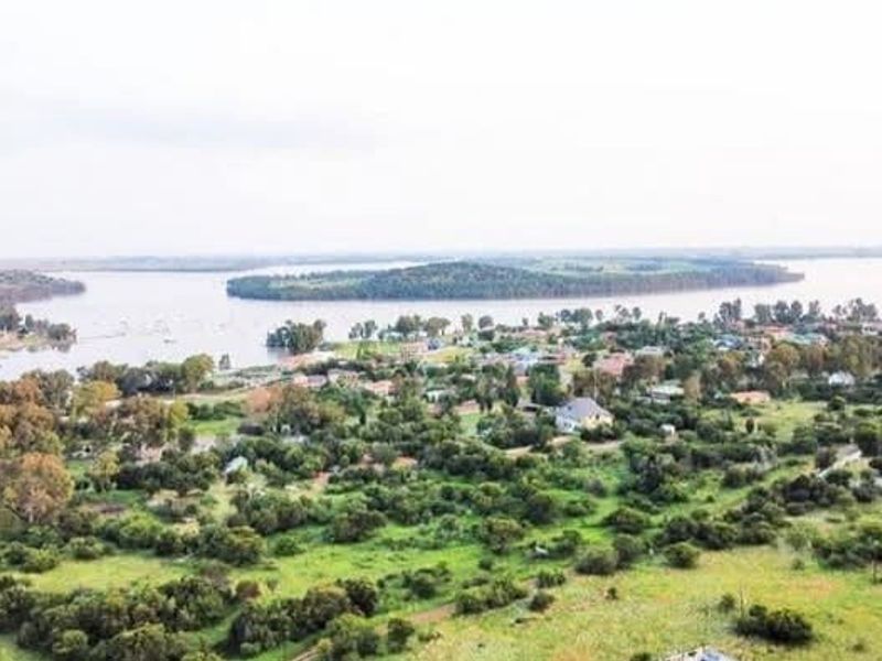 An aerial view of the residential area and surrounding landscape, featuring expansive views of the nearby lake and natural vegetation.