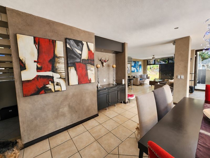 Spacious open-plan living and dining area featuring tiled flooring, neutral textured walls, and large sliding glass doors providing access to the outdoor space.