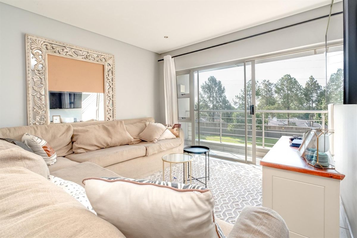 Bright living room featuring large sliding glass doors that open onto a balcony, providing natural light and outdoor access.