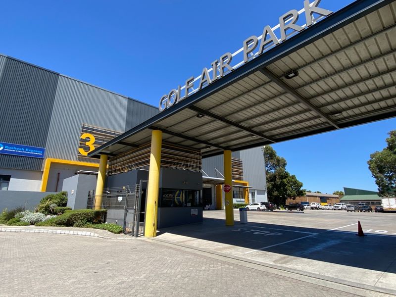 Main entrance and security gatehouse of Golf Air Park, featuring modern industrial metal cladding and a prominent steel canopy structure.