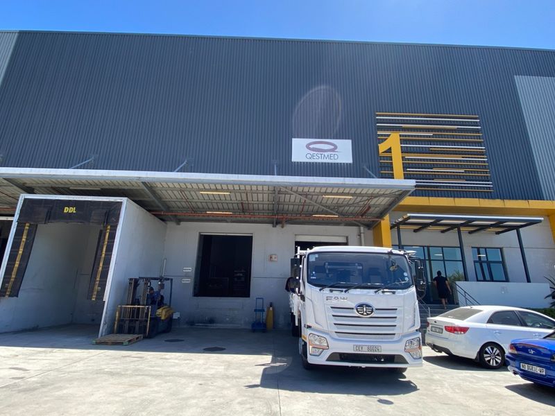 Front elevation of an industrial warehouse facility featuring a loading dock, metal cladding, and a covered entrance area.