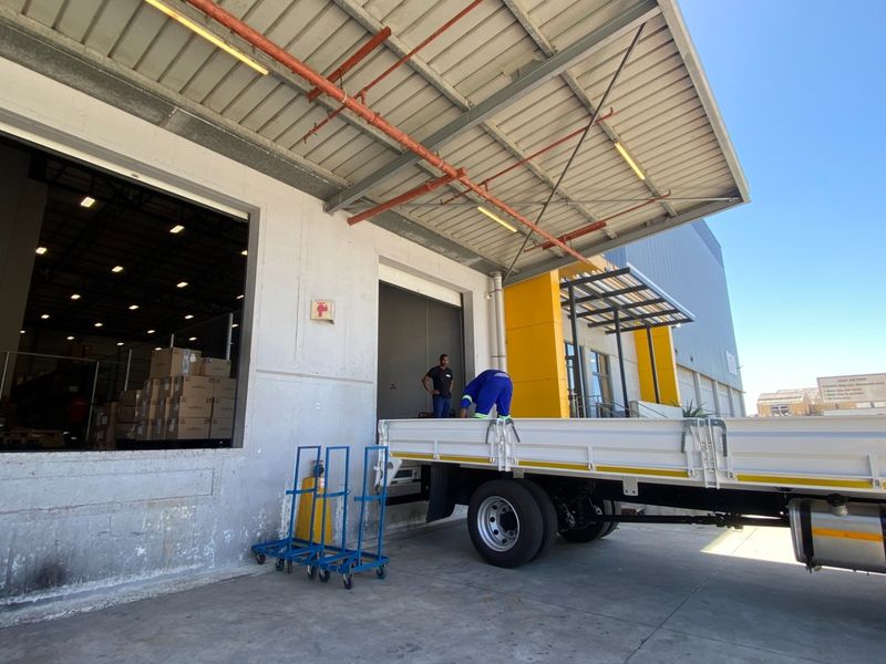 Industrial loading bay area featuring a concrete hardstand, metal canopy, and roller shutter access for efficient goods handling and logistics operations.